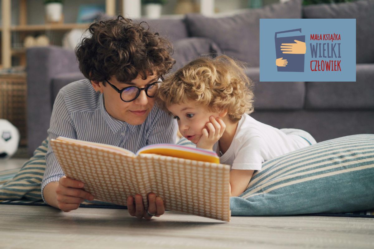 Mama i dziecko leżą na podłodze na poduszkach i czytają książkę, w tle kanapa, w prawym górnym rogu logo
