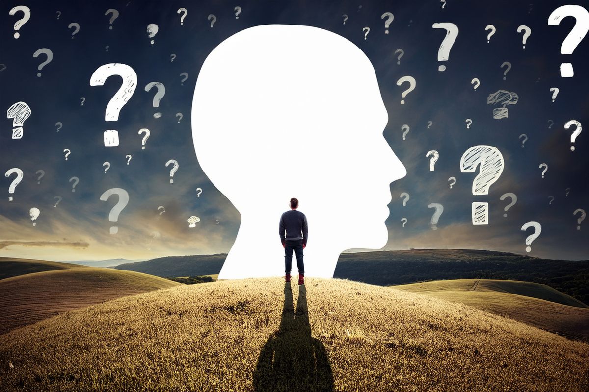 Na tle zachodu słońca świecący zarys ludzkiej głowy, mężczyzna stojący tyłem na górce, wokół znaki zapytania