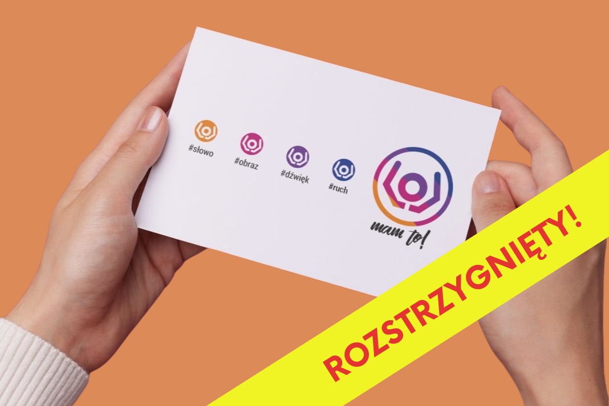Na pomarańczowym tle ręce trzymające kartkę z logotypami konkursu MAM to!, na żółtym pasku napis: Rozstrzygnięty!