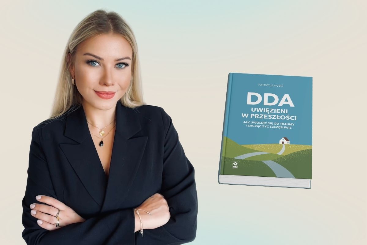 Na beżowym tle blondynka w czarnej marynarce z założonymi rękami, z prawej okładka książki