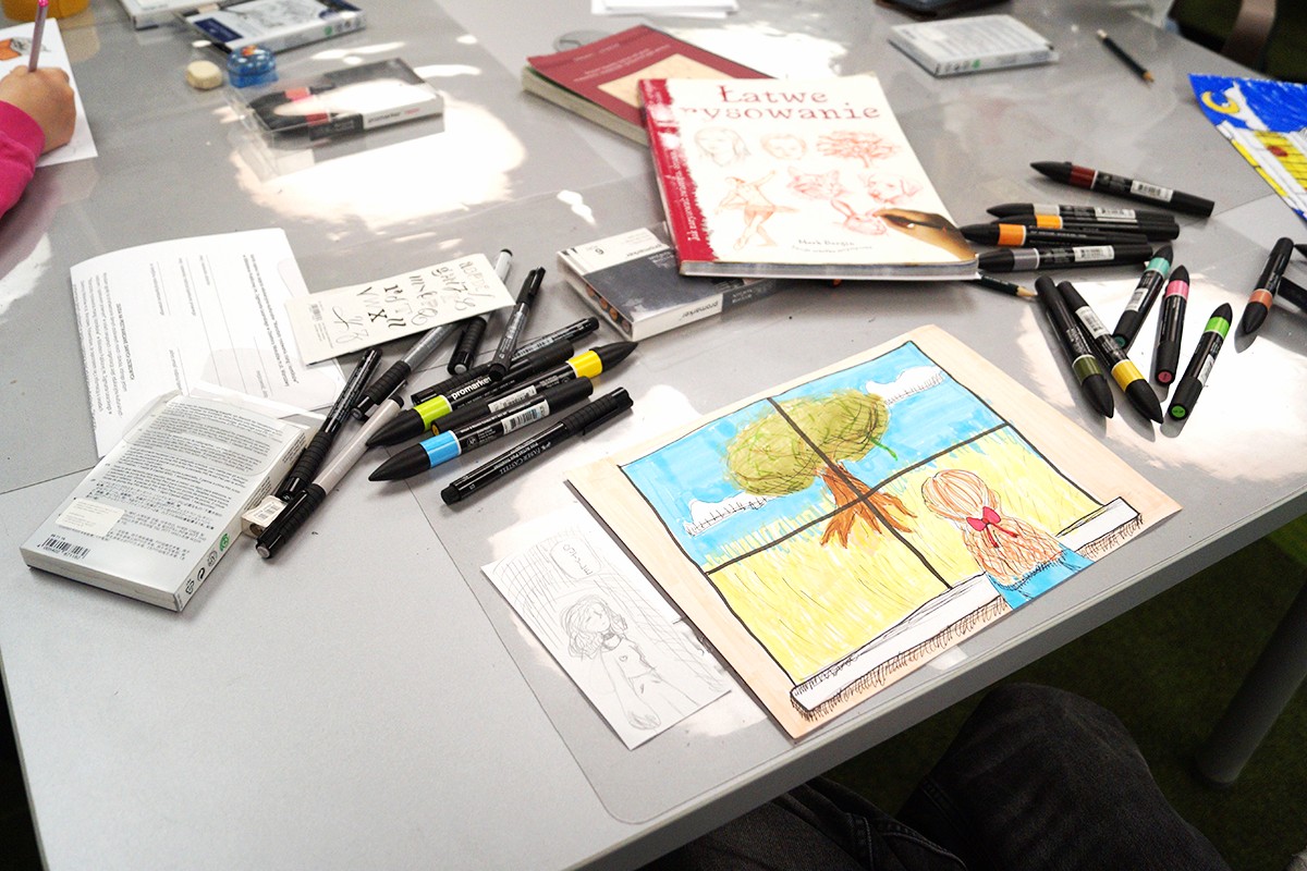 Stół z markerami i rysunkiem drzewa.