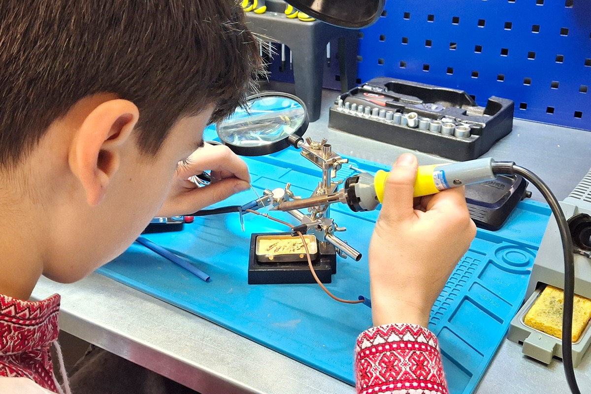 Chłopiec naprawia urządzenie.
