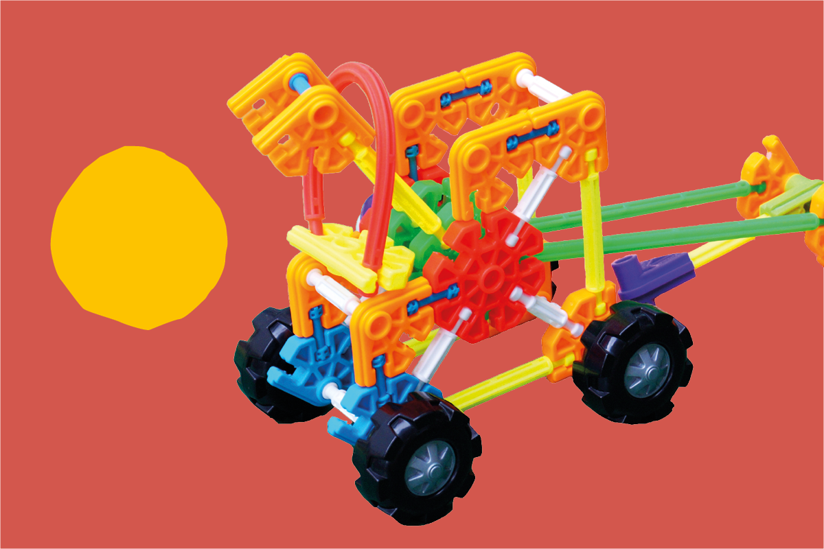 Pojazd skonstruowany z klocków Kid K'nex na brązowym tle; po lewej stronie żółta plama