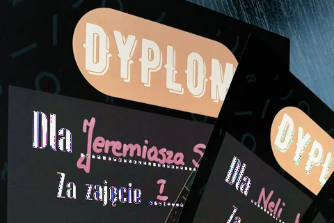 Dwie czarne karki dyplomów. Widać dwie wyróżnione osoby: Jeremiasza i Neli.