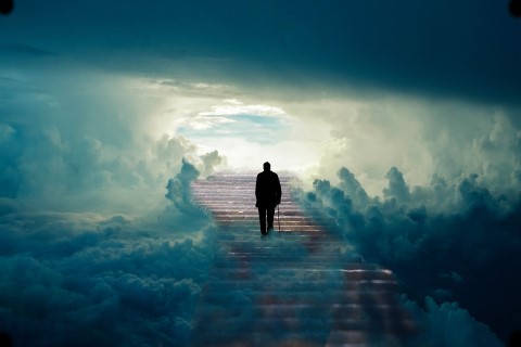 Cień mężczyzny poruszającego się o lasce zmierza po schodach na górę, w stronę nieboskłonu. Otaczają go chmury.