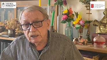 Na zdjęciu Piotr Wojciechowski na tle regału z książkami.