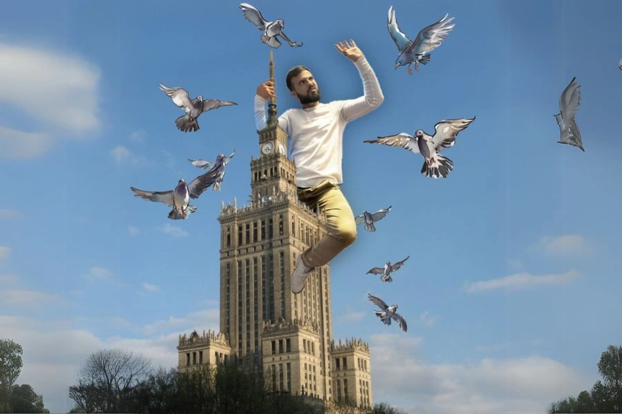 Na tle błękitnego nieba mężczyzna siedzi na Pałacu Kultury, wokół latają ptaki