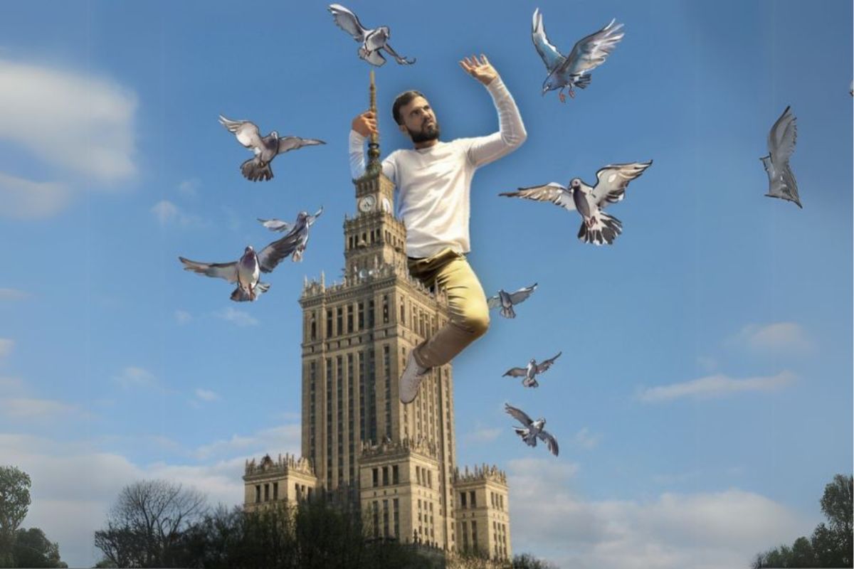 Mężczyzna siedzi na Pałacu Kultury i Nauki i ogania się od ptaków