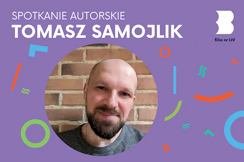 Łysawy mężczyzna z brodą i wąsami uśmiecha się serdecznie do obiektywu.