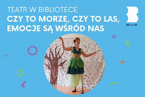 Na zielono ubrana aktorka na tle dekoracji gołego drzewa.