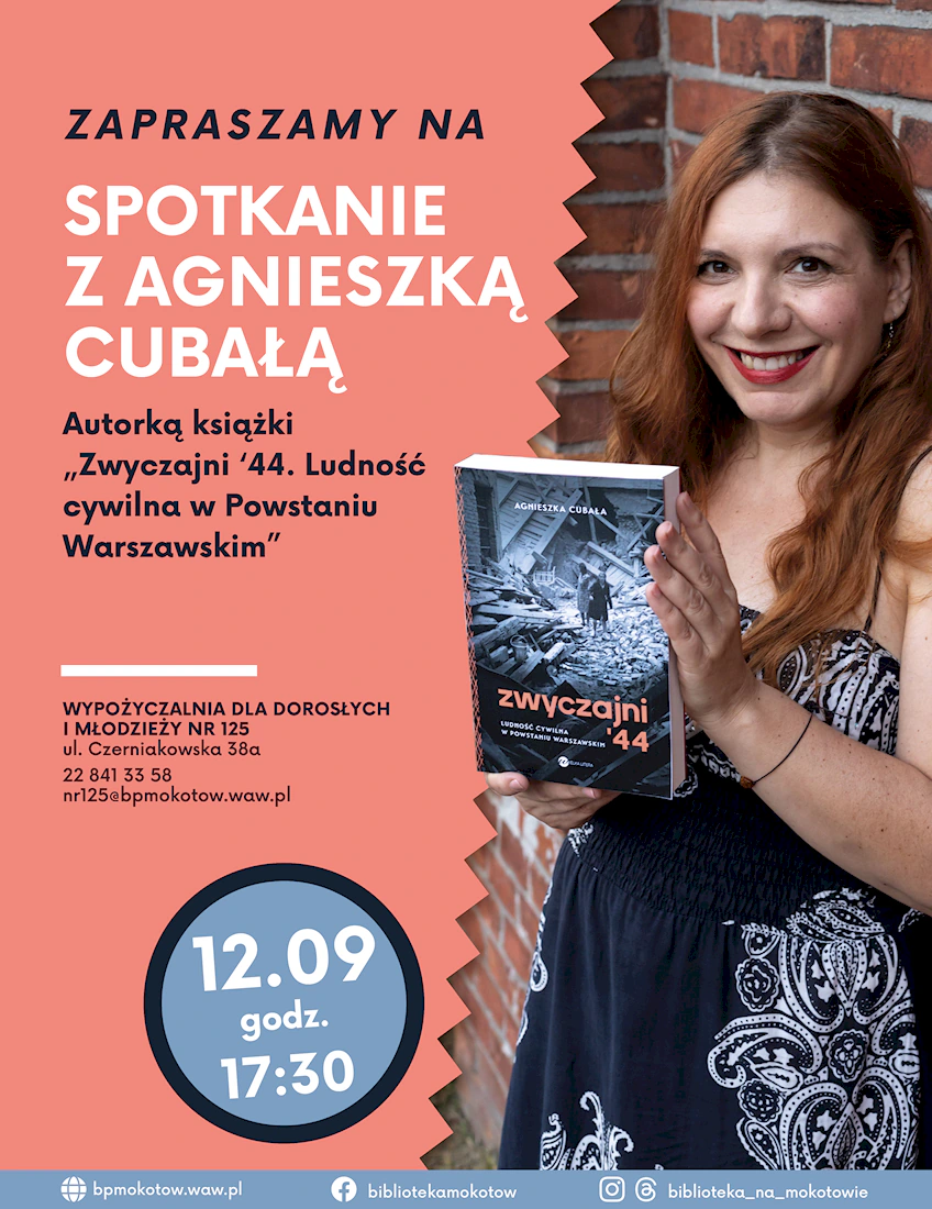 Agnieszka Cubała, rudowłosa kobieta w średnim wieku w granatowej sukience trzyma w dłoniach swoją książkę, na okładce której dominuje motyw ruin warszawskich.