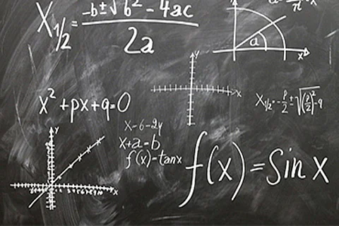 Na zdjęciu szara tablica z równaniami matematycznymi.