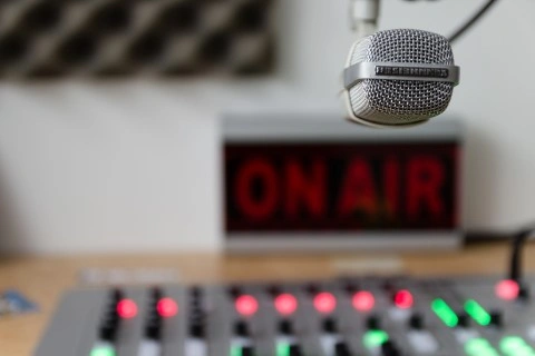 Studio nagrań. Widoczny mikrofon oraz napis on er. 