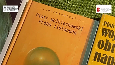 Dwie pomarańczowe książki na zielonym obrusie.