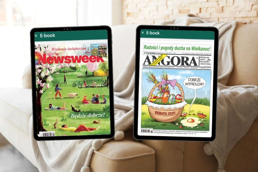 E-prasa na tablecie, w tle kanapa z kocem