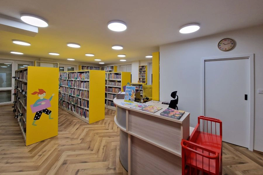 Wnętrze biblioteki, lada biblioteczna i półki z książkami