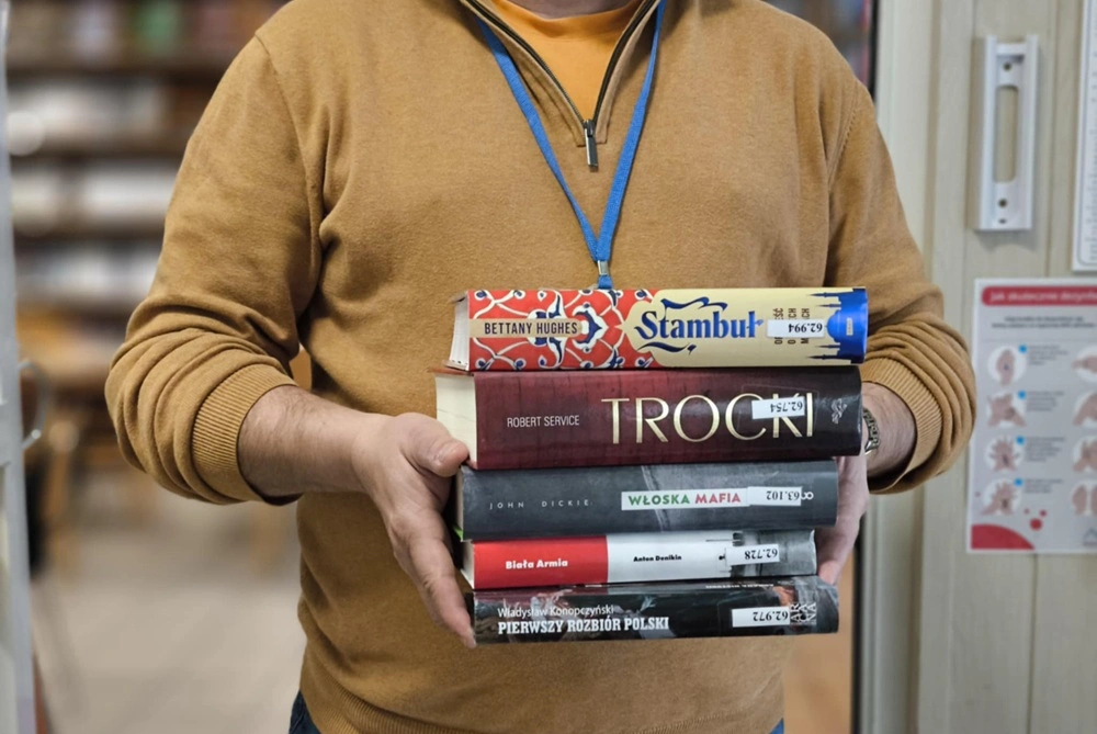 Bibliotekarz trzyma w rękach pięć książek