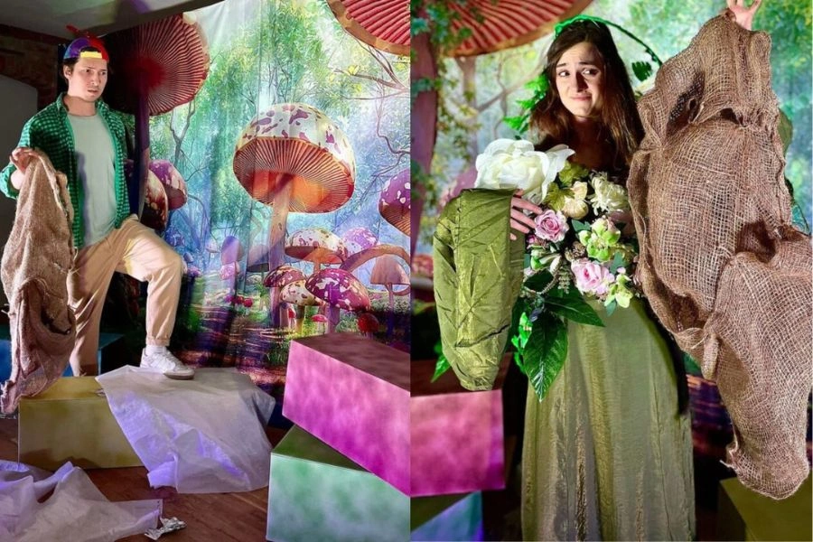Scenografia teatralna: mężczyzna i kobieta trzymają w ręku śmieci