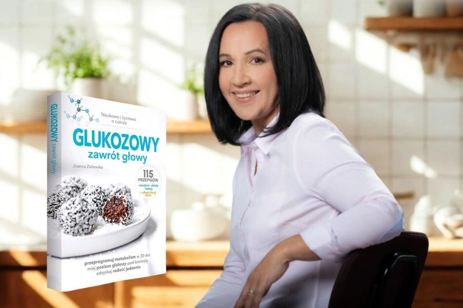 Kobieta siedzi z ręka na oparciu krzesła, w tle widok na kuchnię