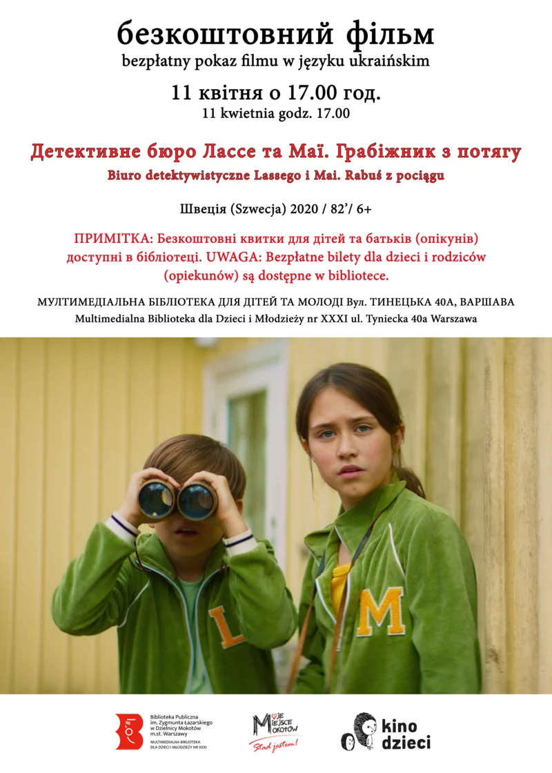 Kadr z filmu: dwójka przyjaciół dziewczynka i chłopiec patrzą przed siebie, chłopiec spogląda przez lornetkę. Na sobie mają zielone bluzy, ona z dużą literą „M”, on z „L”. W tle widać dom.