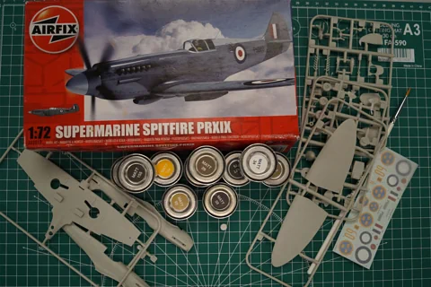 Zdjęcie części modelu samolotu do sklejania i pudełka od zestawu o nazwie SUPERMARINE SPITFIRE PRXIX.