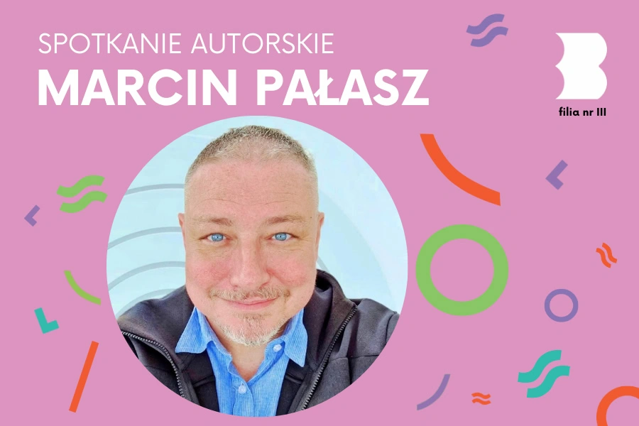 Portret krótko ostrzyżonego mężczyzny z bródką uśmiechającego się do obiektywu.