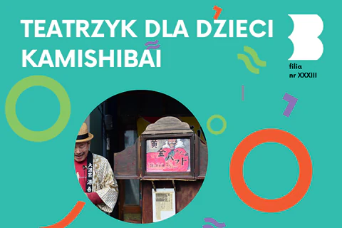 Japończyk stoi obok drewnianej skrzynki, obrazkowego teatrzyka kamishibai.
