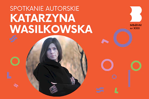Ciemnowłosa kobieta w czarnej bluzie na tle jesiennego parku.