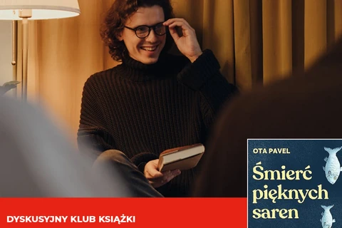 Lampa stojąca oświetla młodego mężczyznę w okularach i brązowym golfie. W prawej ręce trzyma książkę, uśmiechając się do innych osób w pomieszczeniu. Z prawej strony fragment okładki książki. Na niej widać dwie ryby oraz napisy: Ota Pawel, śmierć pięknych saren. Na dole obrazka na czerwonym tle napis: dyskusyjny klub książki.